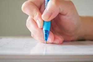 mano de mujer con bolígrafo escribiendo en la fecha del calendario concepto de reunión de cita de planificación empresarial foto