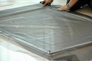 man install mosquito net wire screen on house window protection against insect photo