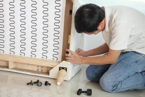 hombre ensamblando muebles de sofá en casa foto