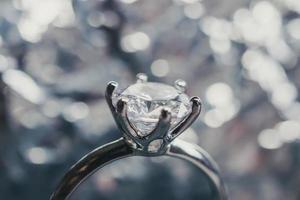 anillo de diamantes de compromiso de lujo con fondo abstracto de luz bokeh foto