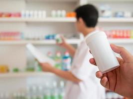 desenfoque farmacéutico tomando medicamentos del estante en la farmacia foto