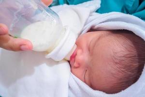 Mother feeding newborn baby from the bottle photo