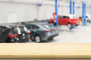 Empty wood table top with car service centre auto repair workshop blurred background photo