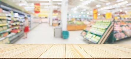 Wood table top with supermarket grocery store blurred defocused background with bokeh light for product display photo