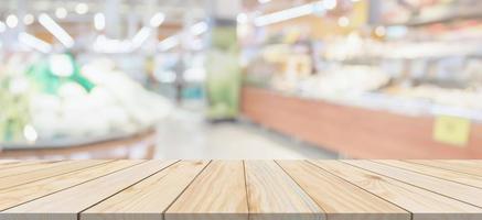 Wood table top with supermarket grocery store blurred defocused background with bokeh light for product display photo