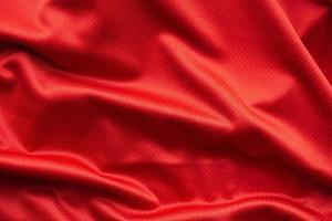 Red sports clothing fabric football jersey texture close up photo