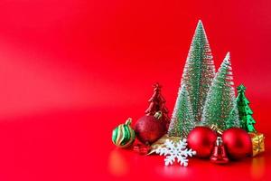 árbol de navidad y adornos sobre fondo rojo concepto de celebración navideña de año nuevo foto