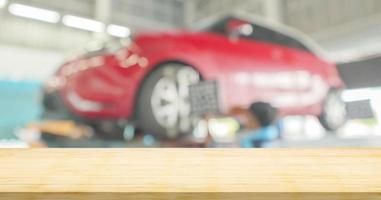 Empty wood table top with car service centre auto repair workshop blurred background photo