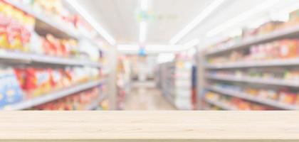 mesa de madera vacía con supermercado tienda de comestibles fondo desenfocado borroso con luz bokeh para la exhibición de productos de montaje foto