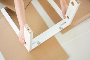 Man assembling white chair furniture at home photo