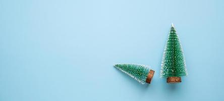 Green Christmas trees on blue pastel background photo