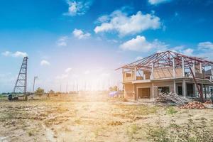 Residential new house building at construction site with clouds and blue sky photo