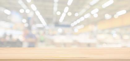 Empty wood table top with supermarket grocery store blurred defocused background with bokeh light for product display photo