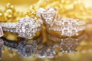 anillos de diamantes de joyería de oro de lujo con reflejo en el fondo negro foto