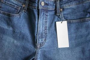 jeans azules con etiqueta de precio blanca en blanco foto