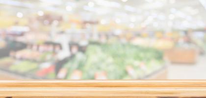 Wood table top with supermarket grocery store blurred defocused background with bokeh light for product display photo