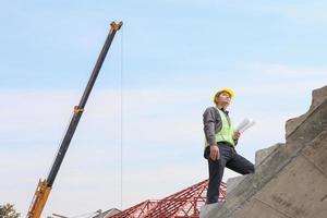 business man engineer worker in protective helmet and blueprints paper on hand at construction site photo