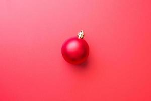 Christmas ball bauble on red background top view photo