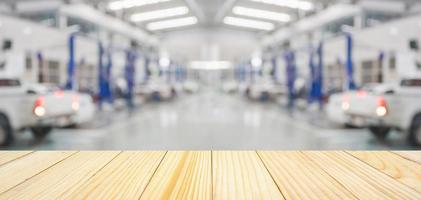 Empty wood table top with car service centre auto repair workshop blurred background photo