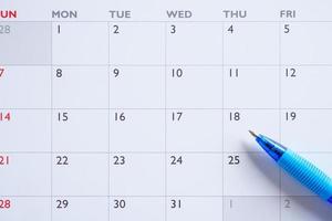 Blue pen on calendar page background business planning appointment meeting concept photo