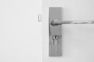 Modern door handle with keyhole on white door photo