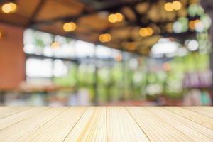 Empty wood table top with abstract blur coffee shop or cafe restaurant background with bokeh light for montage product display photo