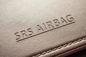 señal de seguridad del airbag en textura de cuero marrón en coche moderno foto