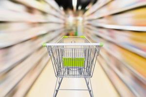empty shopping cart with blur supermarket aisle with baby formula milk product on the shelf, motion blur photo