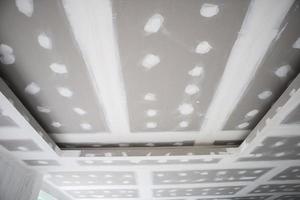 ceiling gypsum board installation at construction site photo