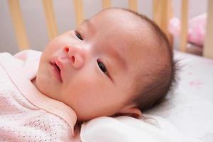 asian baby lying on bed photo