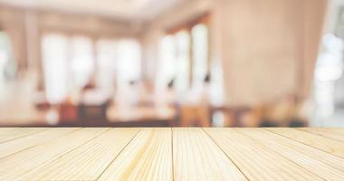 Wood table top with Restaurant cafe or coffee shop interior with people abstract defocused blur background photo