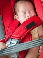 Newborn baby girl sleep in car seat photo