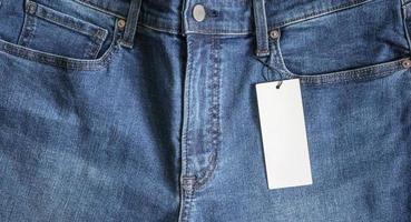 Blue jeans with blank white price label tag photo