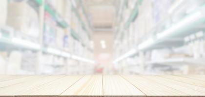 Empty wood table top with blur supermarket or warehouse aisle background photo