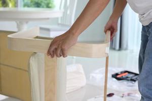 Asian man assembling furniture at home photo