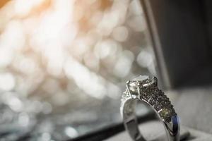 luxury engagement Diamond ring in jewelry gift box with bokeh light background photo
