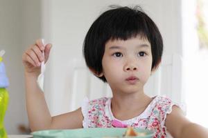 Little asian girl having breakfast photo