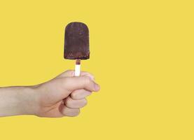 Chocolate ice-cream on yellow background. Popsicle. Eskimo photo