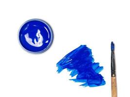 acrílico azul en un frasco. gotas de pintura sobre la mesa. foto