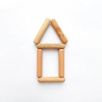 casa hecha de palos de madera sobre fondo blanco. forma simple foto