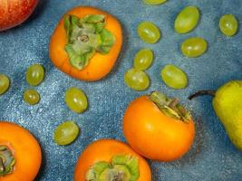 Apple, persimmon and pear on a black background. Persimmon Chamomile. Apple Gala. Pear Lucas. Still life of fruits. Fruit background. Healthy eating. photo