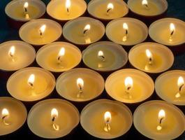 Lots of small lit candles. Dark mysterious atmosphere.Candle background. photo