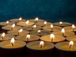 Lots of small lit candles. Dark mysterious atmosphere. Candle background. photo