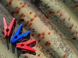 colorful clothespins on textured and rusty surface photo