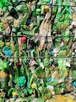 Recycled plastic bottles in bales at a recycling facility. photo