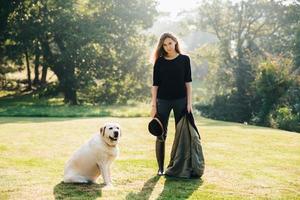 mujer con perro en el césped soleado foto