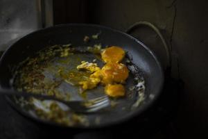 Egg yolk in frying pan. Plug and egg. Steel frying pan. Kitchen at home. photo