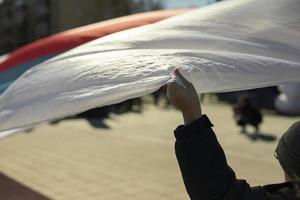 Hand holds flag of Russia. Hand holds on to fabric floating in air. photo