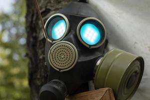 Steam punk gas mask. Glowing eyes at mask. Mask on face from gas. Festival Decoration Details. photo