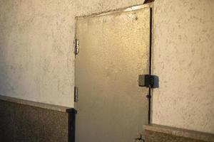 Steel door in wall. Doorway. Details of technical building. Emergency entrance. photo